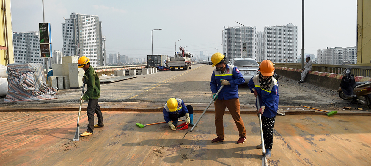 workers clean the surface of Thang Long bridge