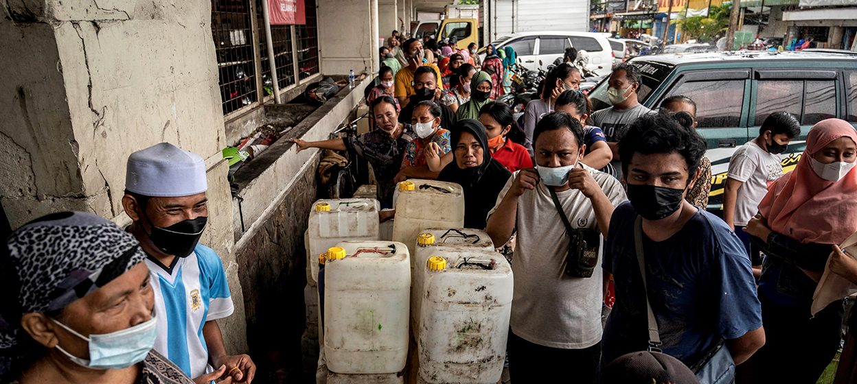 People queue to purchase cooking oil provided by the local