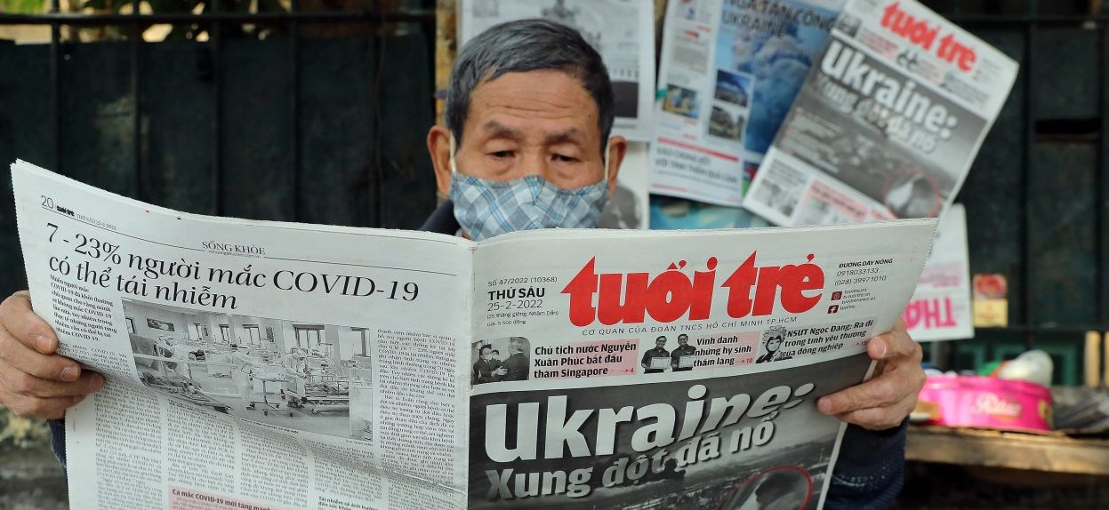 A man reads a Vietnamese newspaper featuring front page coverage of the Russian invasion of Ukraine at a stall in Hanoi on February 25, 2022. (Photo: Nam NGUYEN / AFP)
