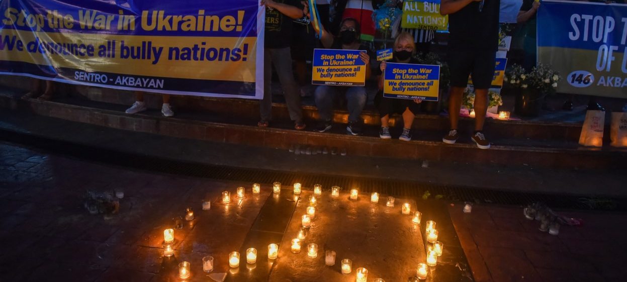 Protesters display placards condemning the invasion of Ukraine during a rally at a monument in Quezon City, suburban Manila on February 28, 2022. (Photo: Maria TAN / AFP)