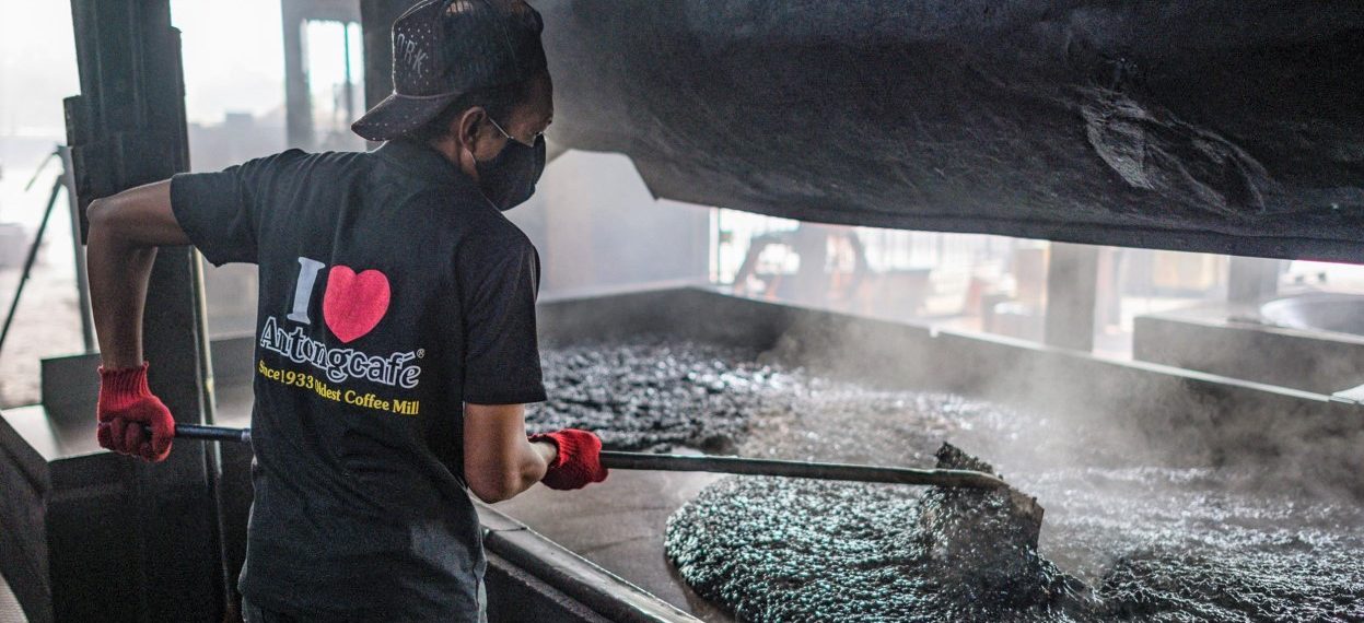 A worker cooling down pre-sweetened black coffee at the Antong Coffee Factory in Taiping in the Malaysian state of Perak on 29 September, 2020. (Photo: Mohd RASFAN/ AFP)