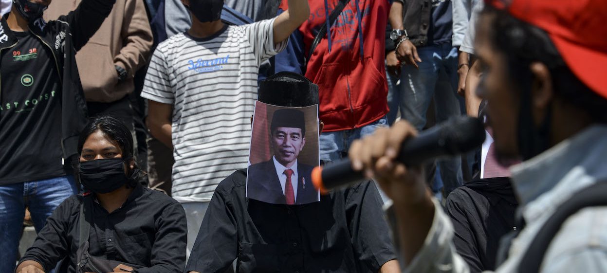 Students cover their faces with Indonesian President Joko Widodo during a demonstration against a controversial new law passed last week which critics fear will favour investors at the expense of labour rights and the environment in Banda Aceh on October 14, 2020. (Photo by Chaideer MAHYUDDIN/ AFP)