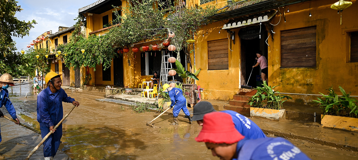 Municipal workers and residents clean up the streets after waters receded in the old city of Hoi An