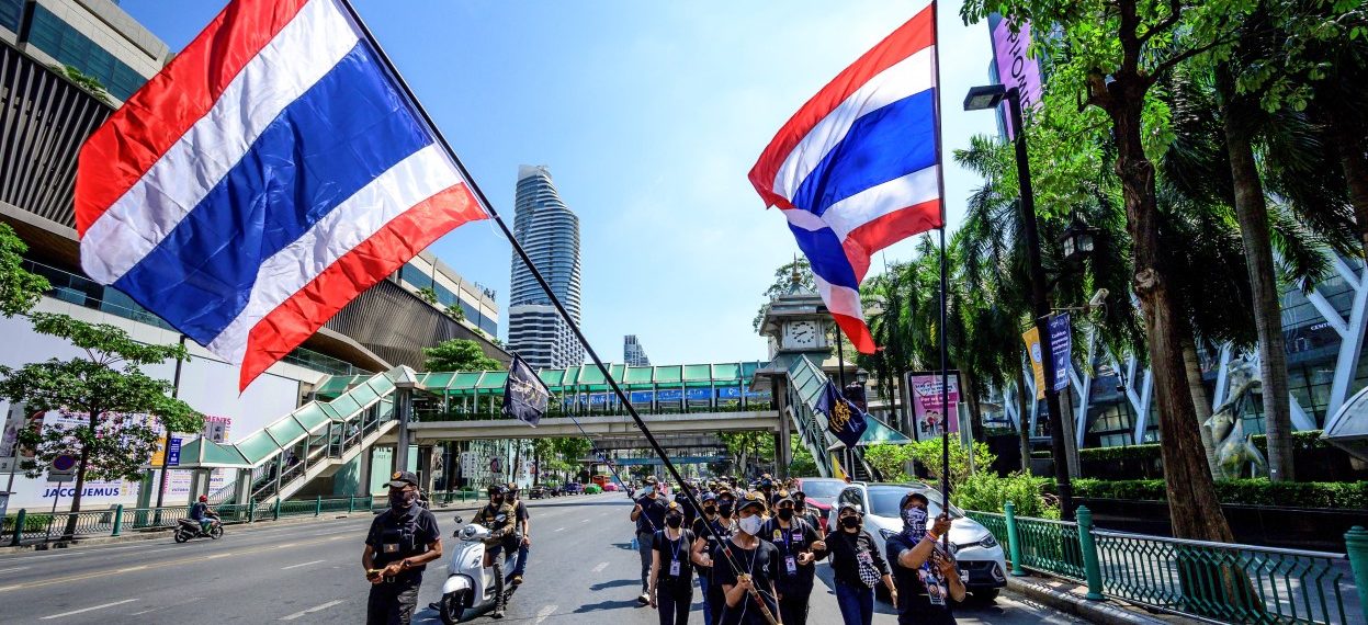 Pro-monarchy activists march with Thai flags during a rally in support of the royal institution in Bangkok on 6 March, 2021. (Photo: Mladen ANTONOV / AFP)