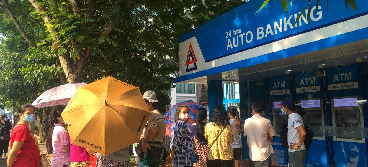 People queue as they wait to withdraw money from automated teller machines (ATM) of KBZ Bank in Yangon on March 18, 2021, amid strained banking operations due to the mass protests against the February military coup. (Photo: STR / AFP)