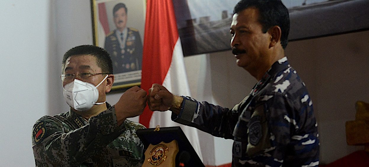 Rear Admiral Iwan Nurcahyanto (L) of Indonesia gives a souvenir to Colonel Chen Yongjing of China after their joint press conference on Lanal base in Denpasar, on Indonesian resort island of Bali, on 18 May, 2021. (Photo: Sonny TUMBELAKA/ AFP)