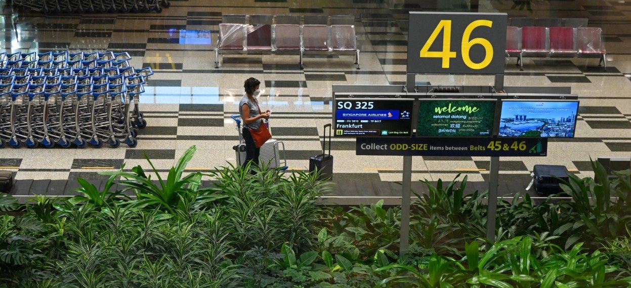 A passenger on Singapore Airlines flight SQ325 -- the first flight to arrive under the new Vaccinated Travel Lane (VTL) -- is pictured in the baggage hall at Changi Airport in Singapore on 8 September, 2021, as travellers vaccinated against the Covid-19 coronavirus arrive from Frankfurt, Germany and are able enter Singapore without quarantine. (Photo: Roslan RAHMAN/ AFP)