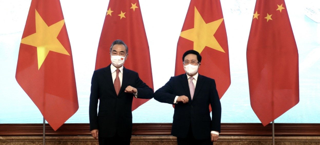 This picture taken and released by the Vietnam News Agency on 10 September 2021 shows Vietnam’s Deputy Prime minister Pham Binh Minh (R) bumping elbows to greet China’s Foreign Minister Wang Yi (L) before a meeting in Hanoi. (Photo: STR/Vietnam News Agency/AFP)