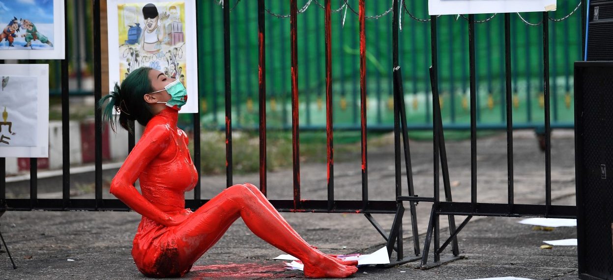 A protester is covered in red paint during a demonstration against the government of Thailand's Prime Minister Prayut Chan-O-Cha and in support of the release of political prisoners outside Bangkok Remand Prison in Bangkok on 13 October, 2021. (Photo: Lillian SUWANRUMPHA / AFP)