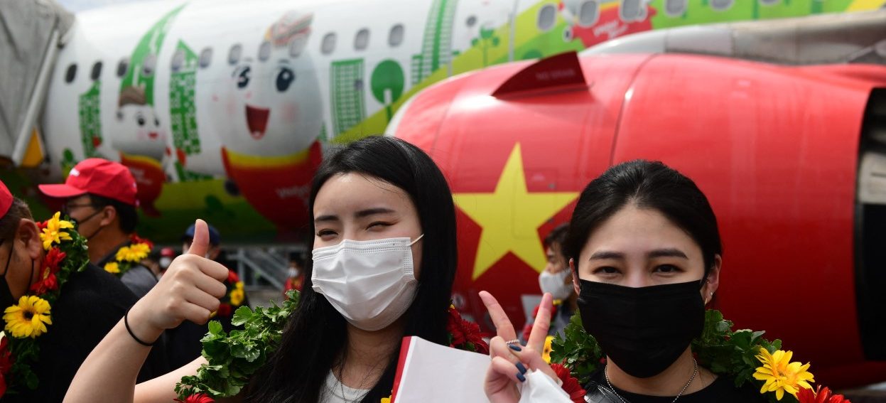 South Korean tourists pose for photos after their arrival at Phu Quoc international airport on 20 November, 2021, as the island welcomes its first international tourists to arrive after a Covid-19 coronavirus vaccine passport scheme kicked off this month in Vietnam. (Photo: Nhac NGUYEN / AFP)