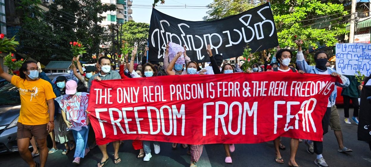 Protesters hold banners as they take part in a demonstration against the military coup in Yangon on 5 December, 2021. (Photo: STR / AFP)