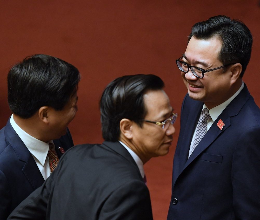 Nguyen Thanh Nghi (R), son of Vietnam's former Prime Minister Nguyen Tan Dung, chats with delegates prior to the opening of the second annual session of the National Assembly in Hanoi on October 23, 2017. Nguyen, who is now the Construction Minister, is the youngest minister in the Cabinet. (Photo by Hoang Dinh NAM/ AFP)