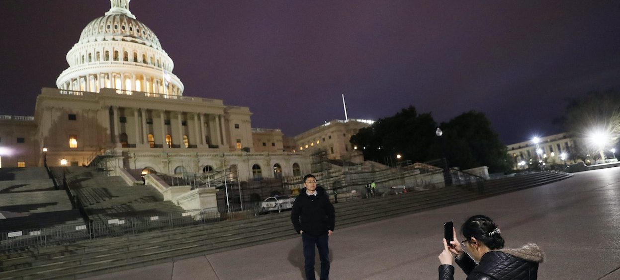 Tourists from China take photos at the U.S. Capitol on 26 January, 2020 in Washington, DC. The defense team will continue its arguments tomorrow in the Senate impeachment trial against President Donald Trump. (Photo: Mario TAMA/ Getty Images via AFP)