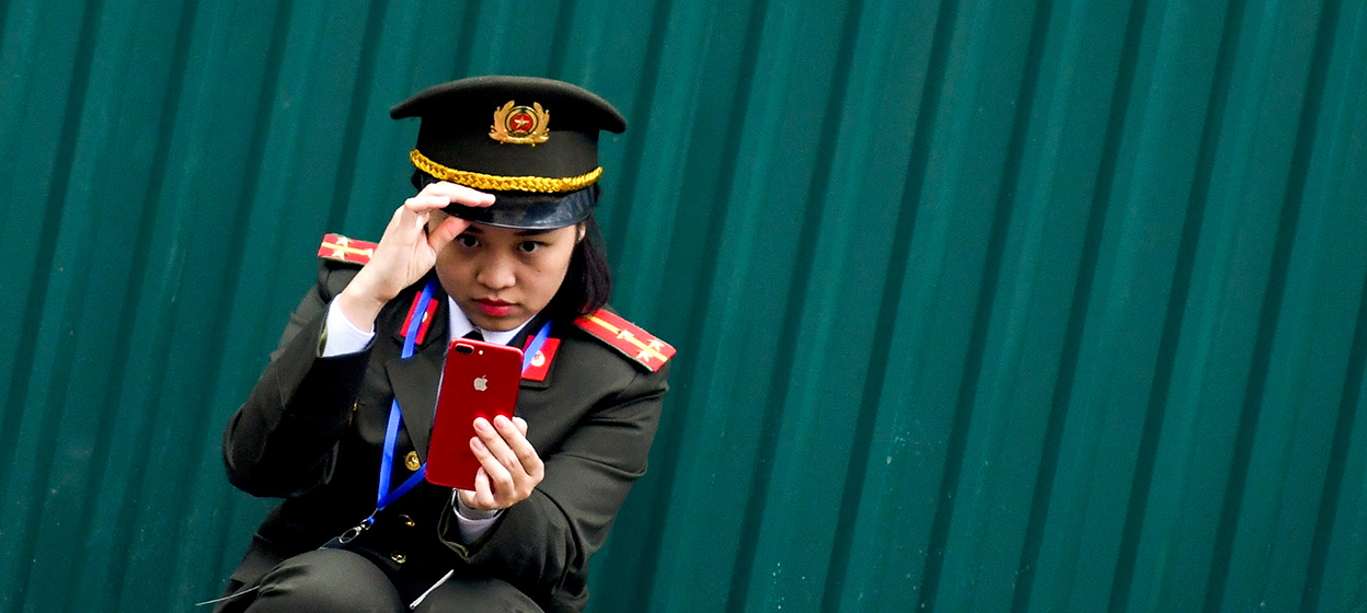 A Vietnamese policewoman uses a mobile phone