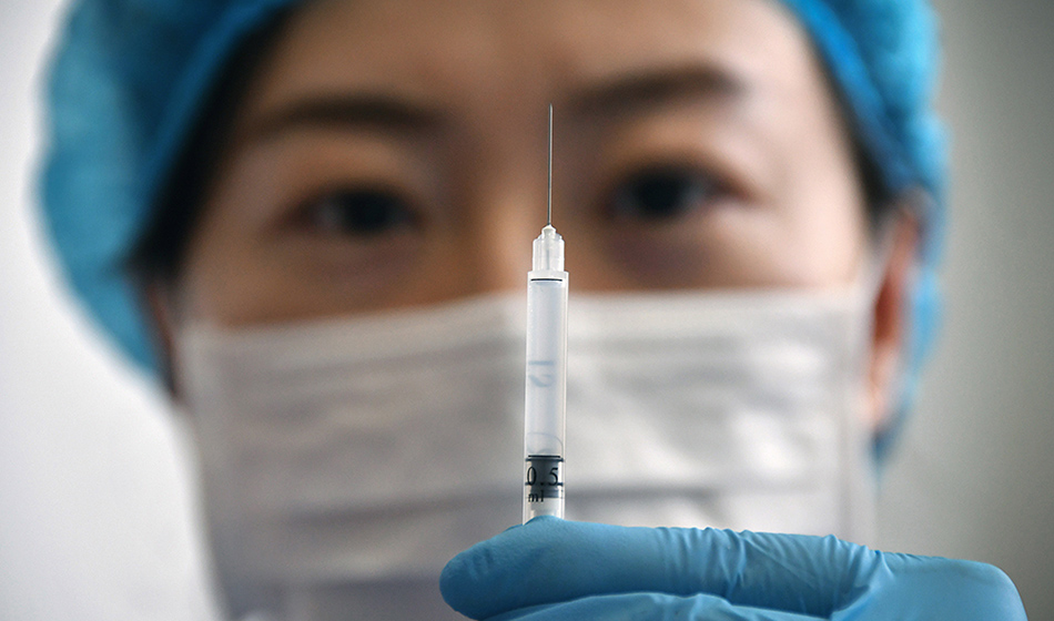 A medical worker shows a syringe with the Sinovac Biotech vaccine