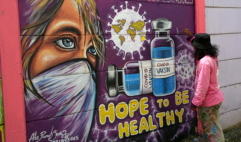 A mural of the Covid-19 vaccine along a street in Tangerang