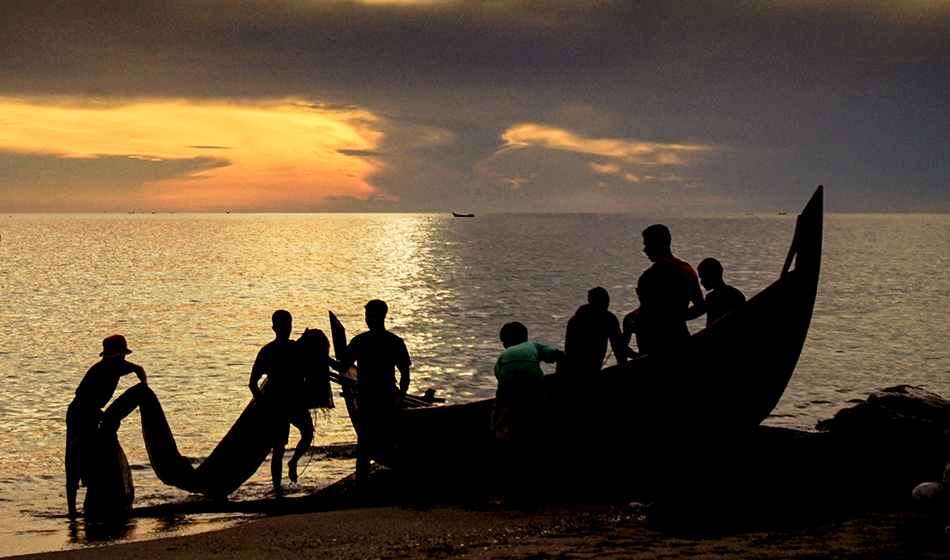 Fishermen tidy up their nets at Hagu Teungah beach, in Lhokseumawe. For