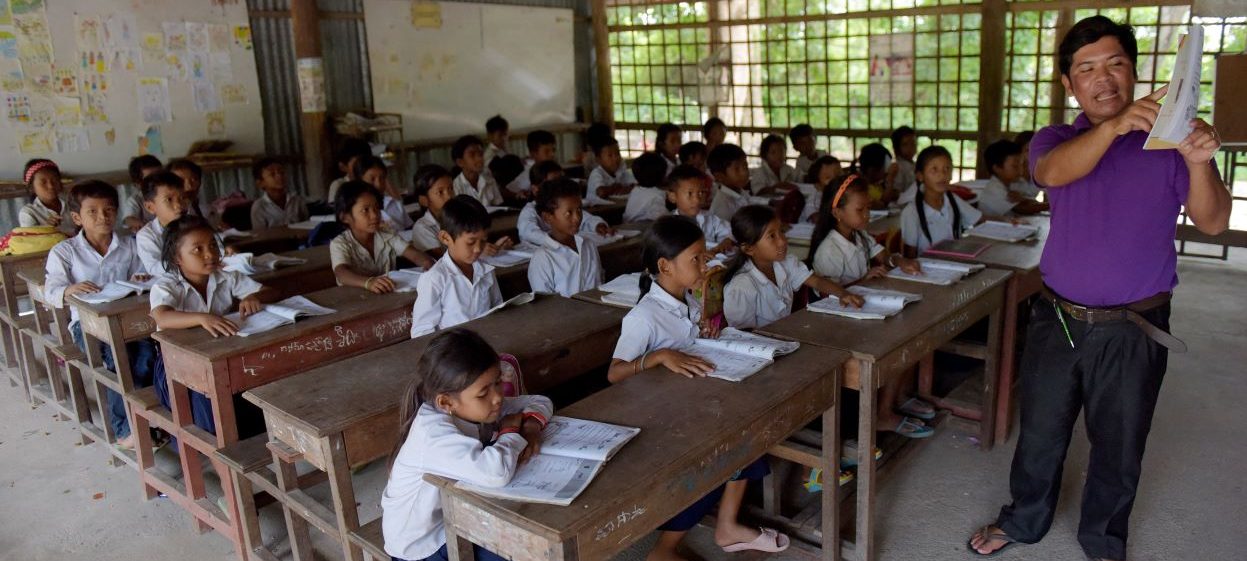 Cambodian teacher talking to students in a classroom of primary school in Kampong Chhnang province