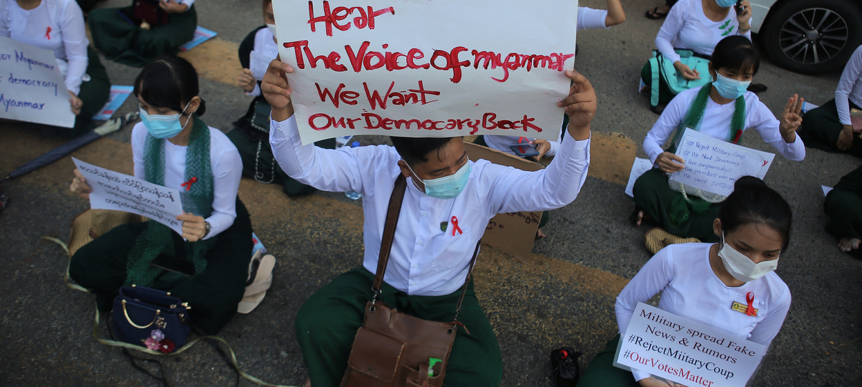 Schoolteachers hold up posters during a sit-down demonstration against the February 1 military coup in Yangon on 9 February 2021.